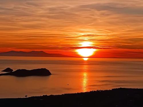 a sunset over a body of water with the sun at Villa with private pool and sea view in Dikili