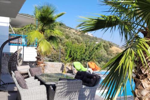 a patio with a table and chairs and a mountain at Villa with private pool and sea view in Dikili