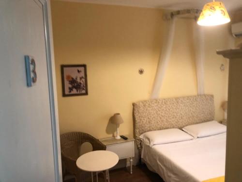 a small bedroom with a bed and a table at B&B Xenia in Mongiove