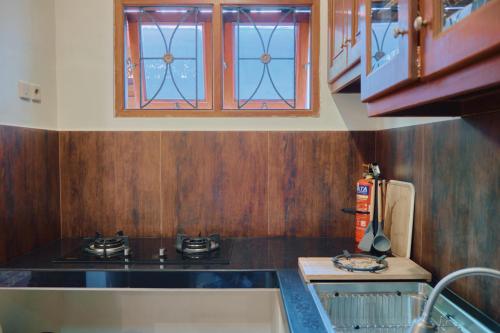 a small kitchen with a stove and a window at nDalem Jobali Guesthouse Jogja in Seturan