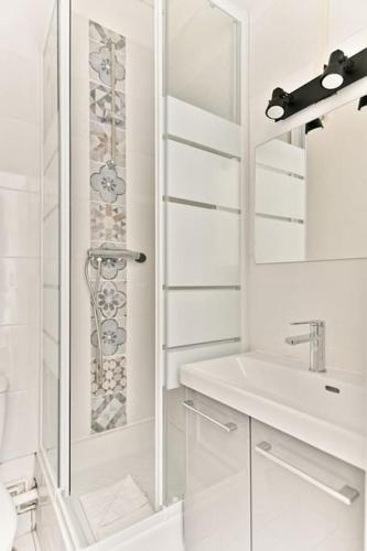 une salle de bain blanche avec une douche et un lavabo dans l'établissement Studio Cosy près de Montparnasse - II, à Paris
