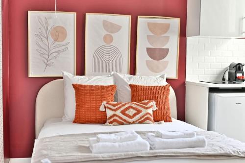 une chambre avec un lit avec des oreillers orange et blancs dans l'établissement Studio Cosy près de Montparnasse - II, à Paris