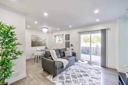 a living room with a couch and a table at 4BR Scarborough Gem, Freshly Renovated, 7 Car Parking in Toronto
