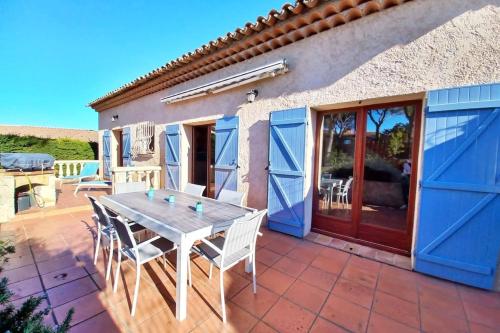 una casa con una mesa y sillas en un patio en Family house - quiet - common pool - Fréjus, en Fréjus