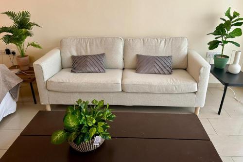 a living room with a couch with two pillows on it at Marlen's Place near Paphos Airport in Paphos City