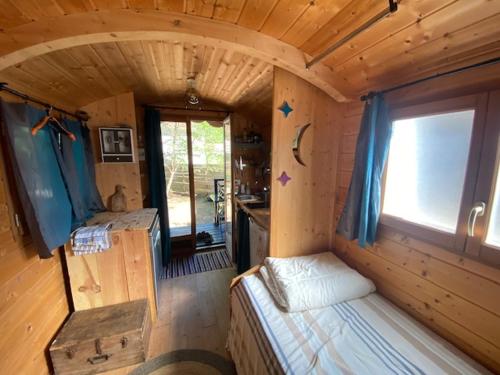 - une chambre avec 2 lits et une fenêtre dans une cabine dans l'établissement Roulotte 300 m de la Plage tout confort, à Soulac-sur-Mer