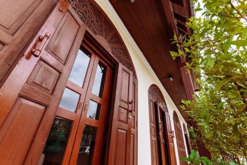 a wooden door of a building with windows at The Author - Fong Lee CC Lampang Walking Street in Lampang