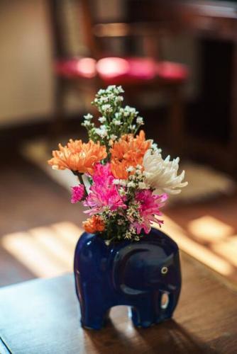 a blue vase filled with flowers on a table at The Author - Fong Lee CC Lampang Walking Street in Lampang