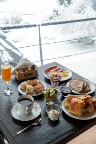 a table with plates of food and cups of coffee at Arrayan Lake View Mountain Lodge & Casa De Te Arrayan in San Martín de los Andes