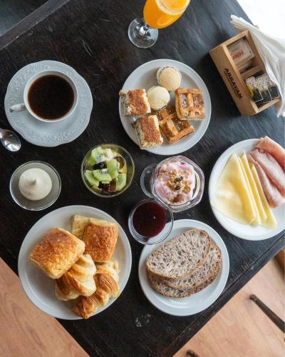a table with plates of food and a cup of coffee at Arrayan Lake View Mountain Lodge & Casa De Te Arrayan in San Martín de los Andes