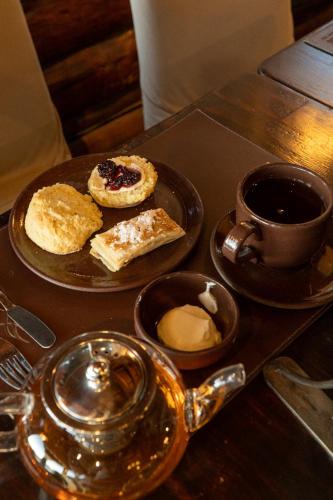 a table with a plate of pastries and a cup of coffee at Arrayan Lake View Mountain Lodge & Casa De Te Arrayan in San Martín de los Andes