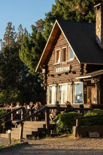 a group of people sitting in front of a building at Arrayan Lake View Mountain Lodge & Casa De Te Arrayan in San Martín de los Andes