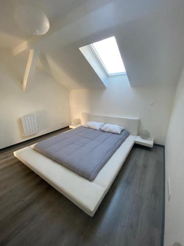 Cette chambre blanche dispose d'un grand lit et d'une fenêtre. dans l'établissement Alsace séjours, à Pulversheim
