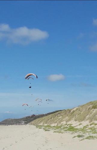 a group of kites flying over a sandy beach at La Cabine d HARDELOT Plage à 3mn à pied in Neufchâtel-Hardelot