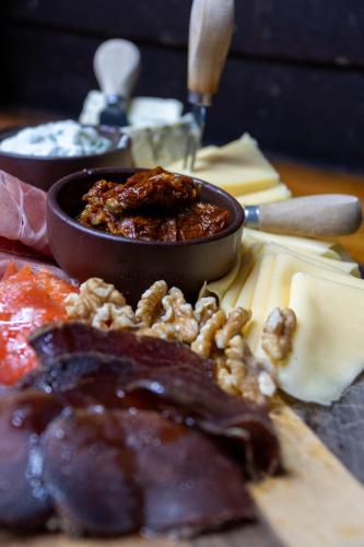 a table with a plate of food with meat and nuts at Arrayan Lake View Mountain Lodge & Casa De Te Arrayan in San Martín de los Andes