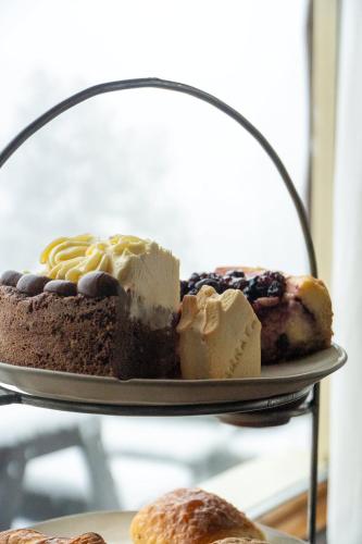 a plate with a piece of cake and pastries on it at Arrayan Lake View Mountain Lodge & Casa De Te Arrayan in San Martín de los Andes