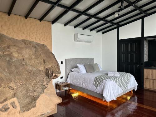 a bedroom with a bed and a large rock at VIP Glamping Ruitoque, Hermosa Vista in Floridablanca