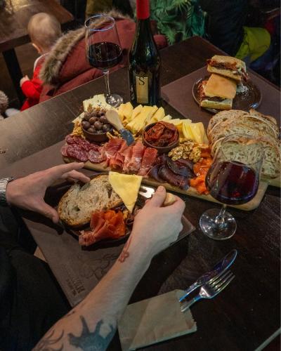 a table with a plate of food and glasses of wine at Arrayan Lake View Mountain Lodge & Casa De Te Arrayan in San Martín de los Andes