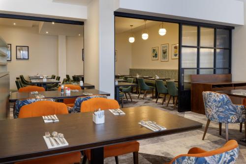 a dining room with tables and chairs and a cafeteria at DoubleTree by Hilton London Chelsea in London