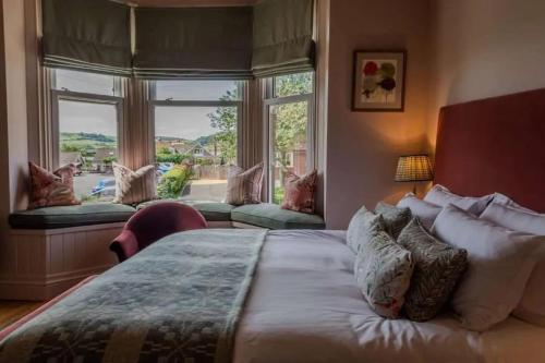 a bedroom with a large bed and a large window at Hotel Victoria in Whitby