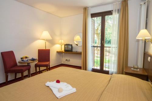 a hotel room with a bed with a towel on it at Hotel Vile Park in Portorož
