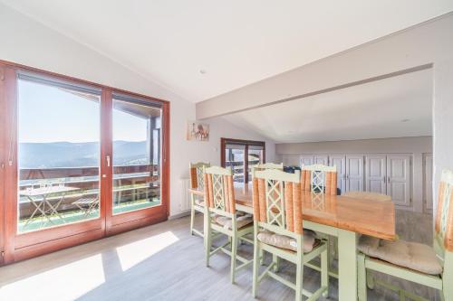 une salle à manger avec une table et des chaises et une grande fenêtre dans l'établissement Le Petit Gîte de la Vallée - Vue montagne parking, à Metzeral