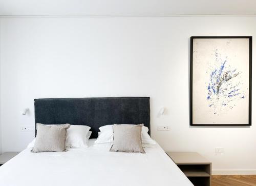 a bedroom with a white bed with a black headboard at Mamas in Oristano