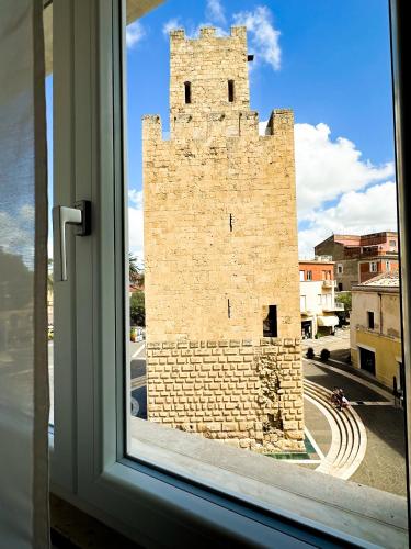 a window with a view of a tall brick building at Mamas in Oristano