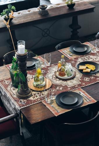 een houten tafel met borden met eten erop bij Azara Beach House - 5 BHK Designer Villa, Candolim Beach in Goa