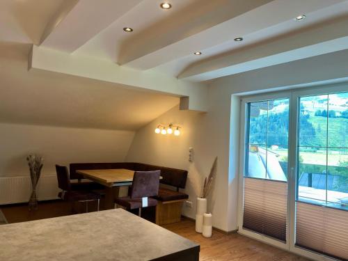 a dining room with a table and a large window at Mooslodge in Kaprun