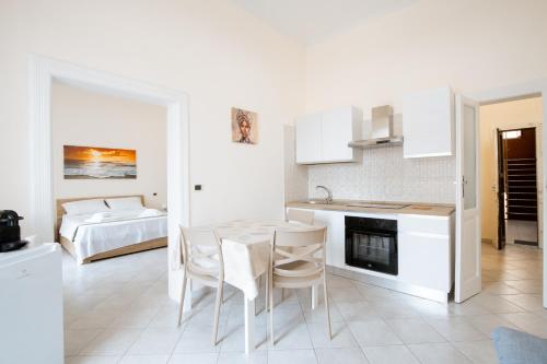 a kitchen and living room with a table and chairs at Krisà Apartment in Bari