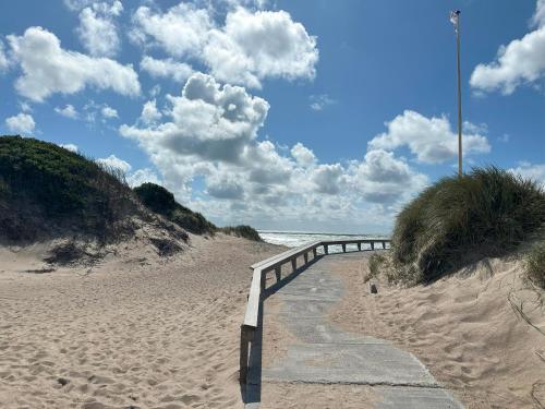 a path leading to a sandy beach next to the ocean at Agger Glamping - Fyret in Vestervig