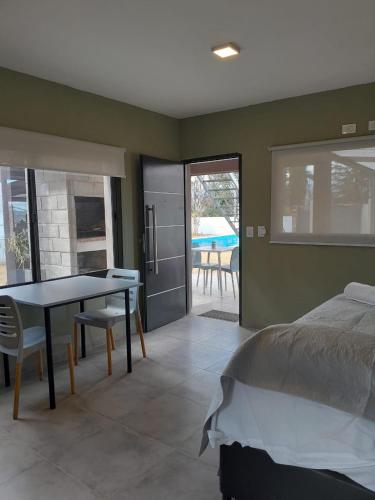a bedroom with a bed and a table and a dining room at Acacias Mina Clavero in Mina Clavero