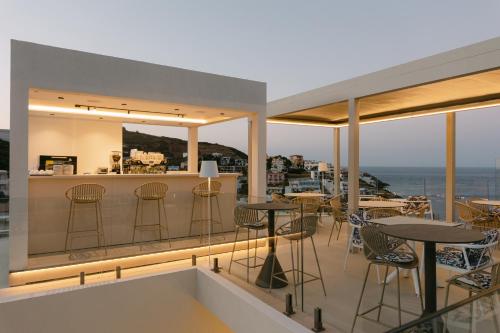 a restaurant with tables and chairs on a balcony at Golden Luxury Suites in Balíon