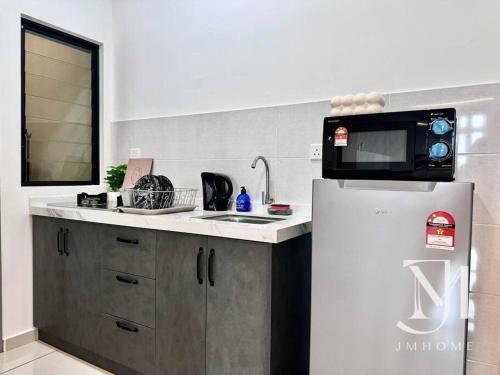 a kitchen with a microwave on top of a refrigerator at Parkland Batu11 2BR MRT Free Parking #22 in Cheras