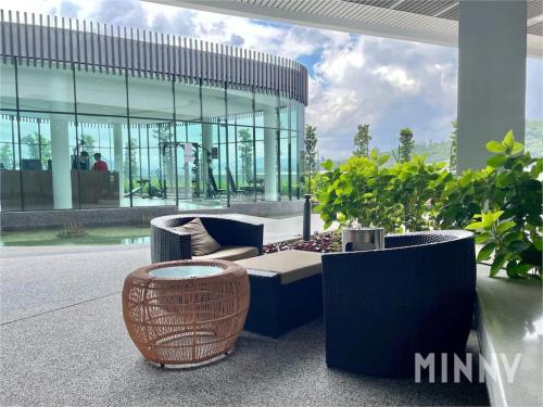 a patio with a couch and chairs and a building at Parkland Batu11 2BR MRT Free Parking #22 in Cheras