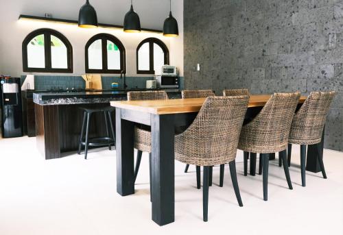 Una cocina con una mesa y sillas de madera. en Luna Ola Villa Berawa, en Canggu