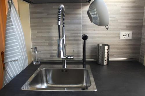 a kitchen sink with a faucet and a fan at Anita's House in Rome