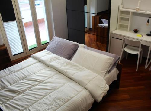 a large white bed in a room with a desk at Anita's House in Rome