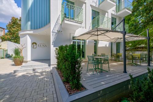 a patio with a table and an umbrella at Luna Residence Villa in Timişoara