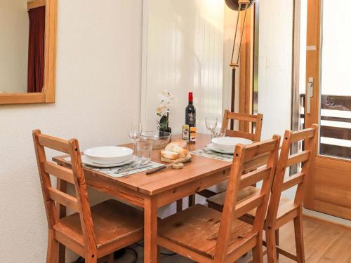 a wooden table with two chairs and a bottle of wine at Apartment Rosablanche C22 by Interhome in Siviez