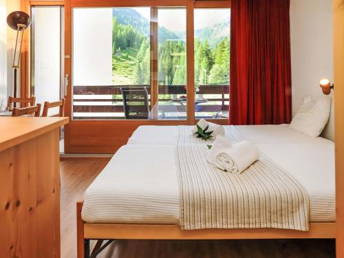 two beds in a room with a large window at Apartment Rosablanche C22 by Interhome in Siviez