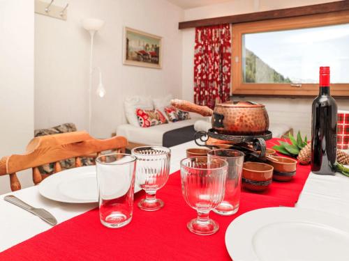 a table with a bottle of wine and glasses on it at Apartment Rosablanche E36 by Interhome in Siviez
