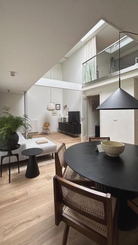 a living room with a black table and chairs at Luxury spacious private loft, between city & beach in Heemstede