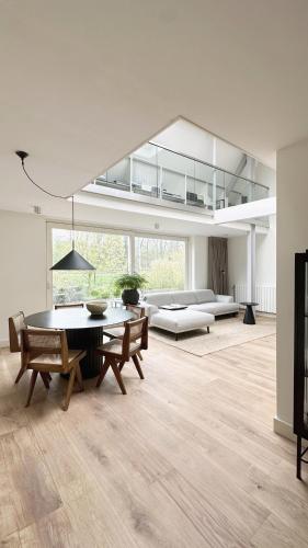 a large living room with a table and chairs at Luxury spacious private loft, between city & beach in Heemstede