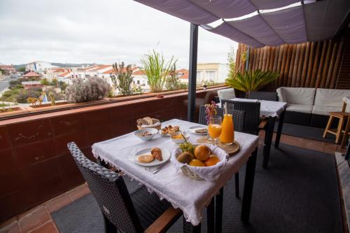 a table with a bowl of fruit on a balcony at Villa Center - Alojamento Local in Grândola