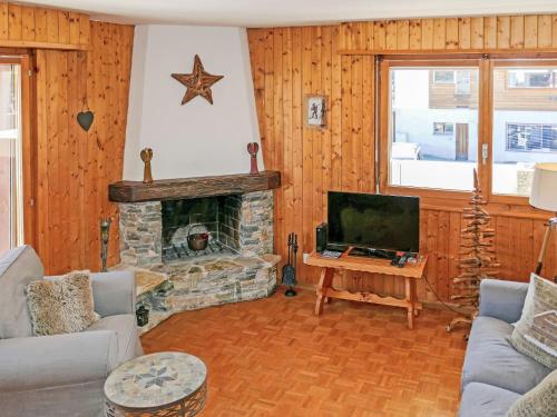 a living room with a fireplace and a tv at Apartment Grand Place 5 by Interhome in Nendaz