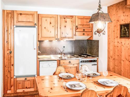 a kitchen with wooden cabinets and a wooden table with chairs at Apartment Grand Place 5 by Interhome in Nendaz
