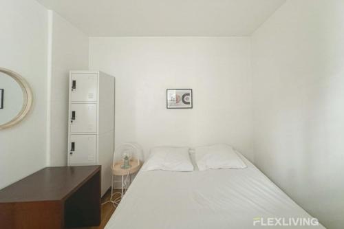 une petite chambre avec un lit et un bureau dans l'établissement Flexliving - room - Banquier, à Paris