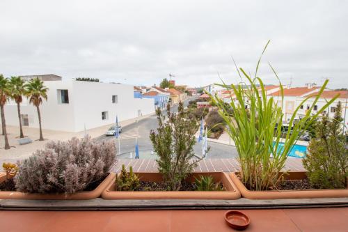 una fila de plantas en un balcón con una calle en Villa Center - Alojamento Local, en Grândola